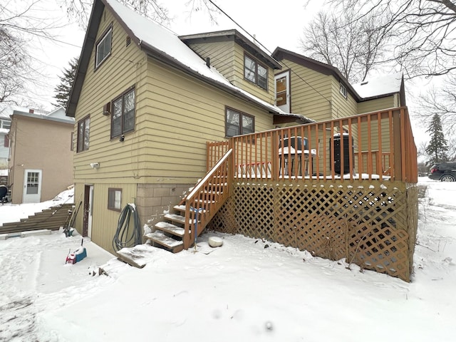 snow covered house featuring a deck