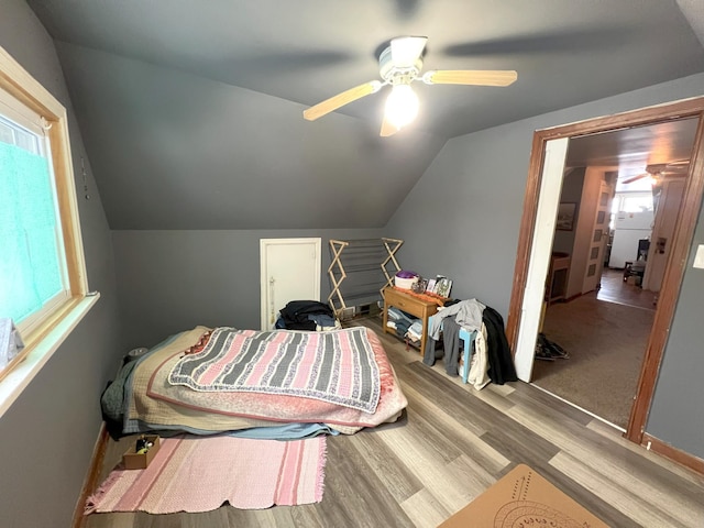 bedroom with vaulted ceiling, light hardwood / wood-style floors, and ceiling fan