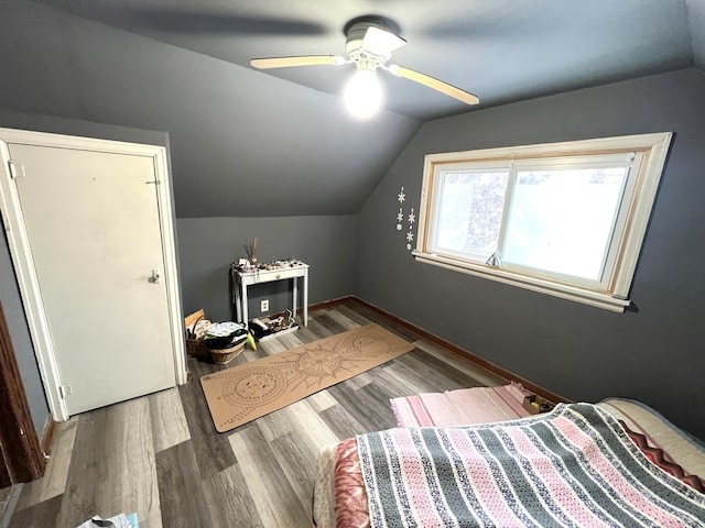 bedroom featuring ceiling fan, wood-type flooring, and vaulted ceiling