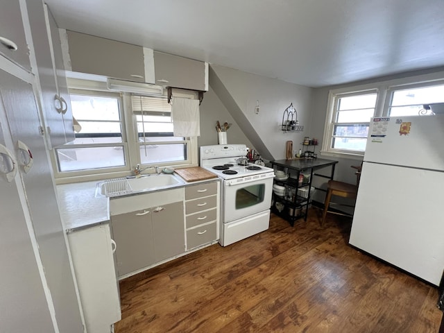 kitchen with dark hardwood / wood-style flooring, sink, white cabinets, and white appliances