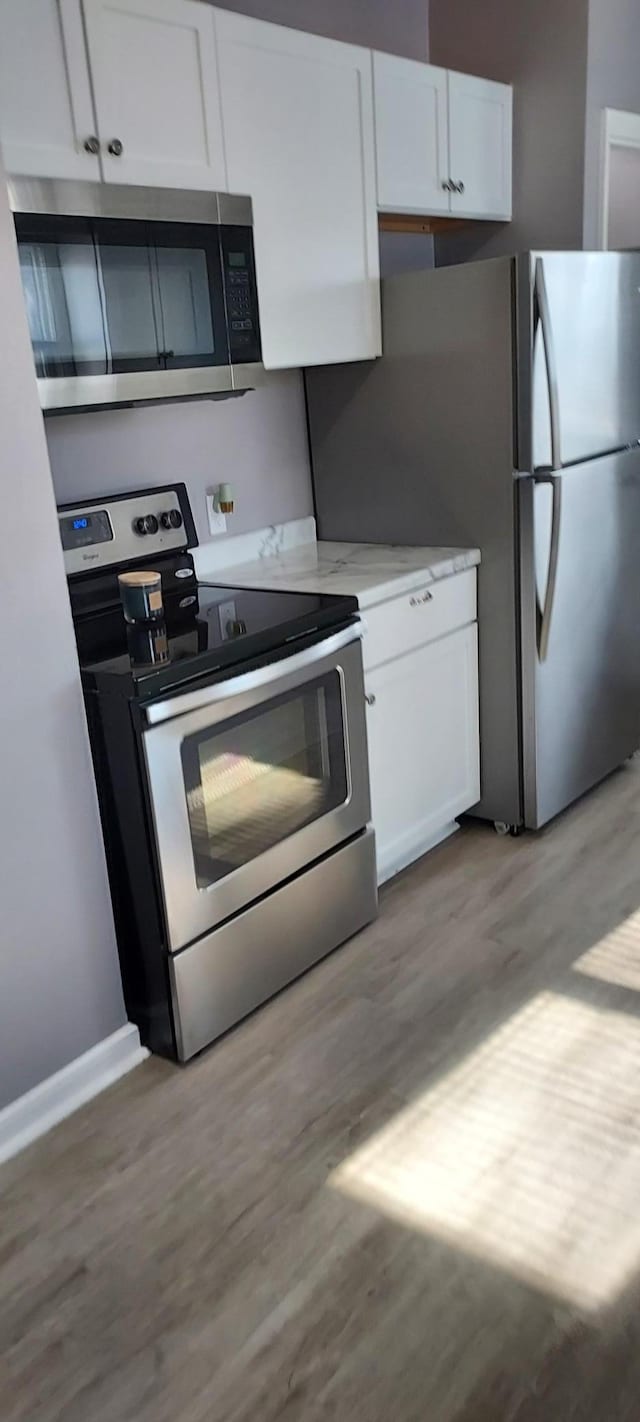 kitchen featuring white cabinetry, appliances with stainless steel finishes, and light hardwood / wood-style floors