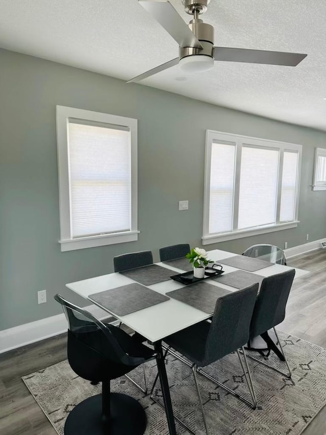 dining room featuring ceiling fan, wood-type flooring, and a textured ceiling