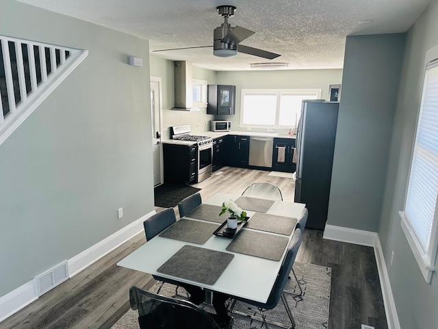 dining area featuring ceiling fan, hardwood / wood-style flooring, and a textured ceiling