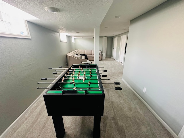 game room with a textured ceiling and carpet flooring