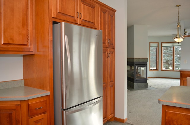 kitchen featuring pendant lighting, stainless steel fridge, and light colored carpet