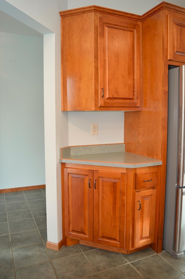 kitchen with stainless steel refrigerator and dark tile patterned floors