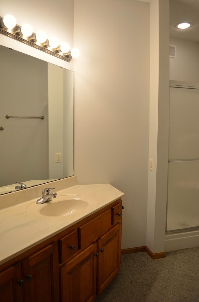 bathroom with vanity and a shower with shower door