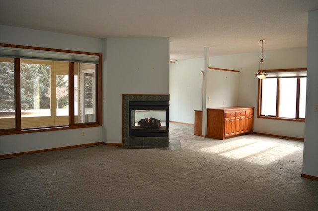 unfurnished living room featuring light colored carpet and a multi sided fireplace