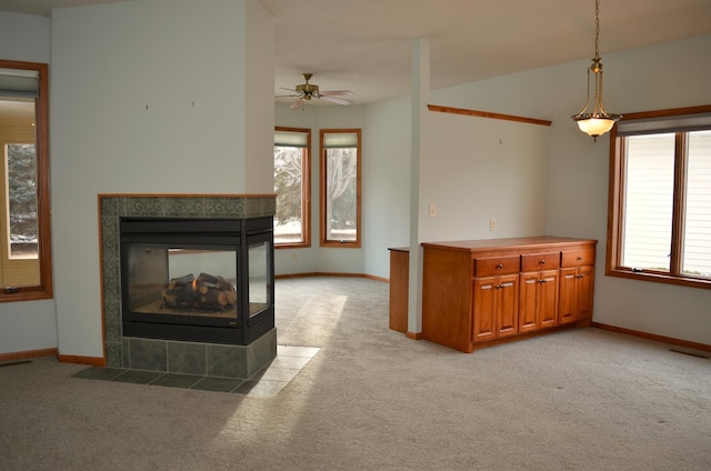 unfurnished living room featuring ceiling fan, light colored carpet, a fireplace, and vaulted ceiling