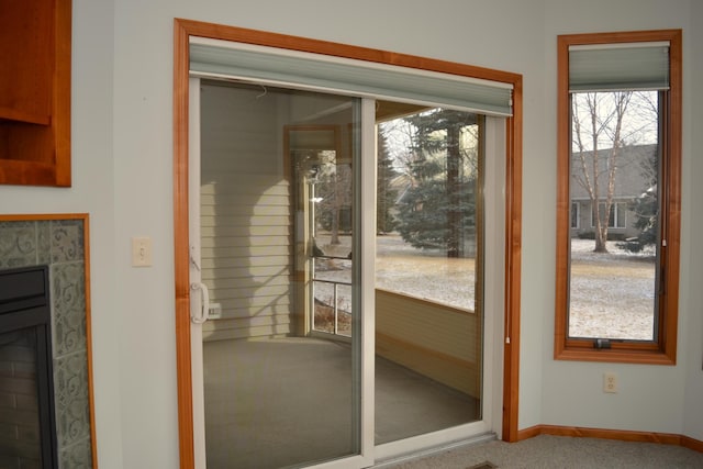 doorway featuring a tile fireplace and carpet floors