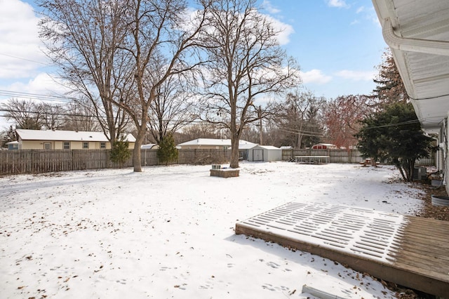 yard layered in snow featuring a storage unit