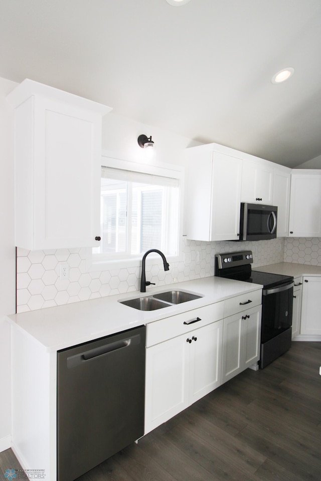 kitchen featuring sink, tasteful backsplash, appliances with stainless steel finishes, dark hardwood / wood-style floors, and white cabinets