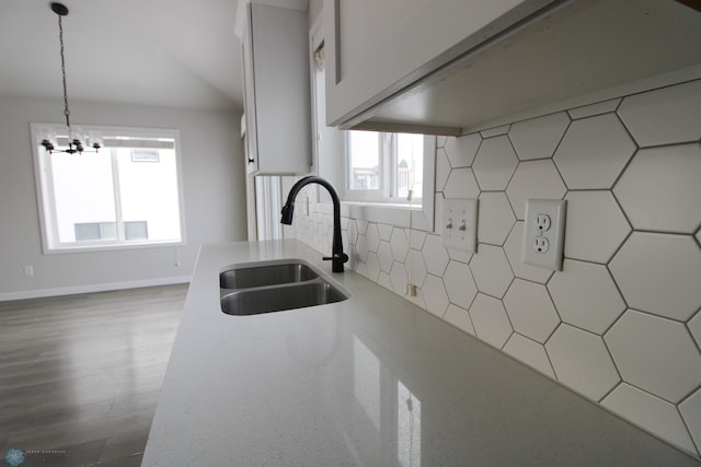 kitchen featuring sink, decorative light fixtures, a notable chandelier, decorative backsplash, and white cabinets