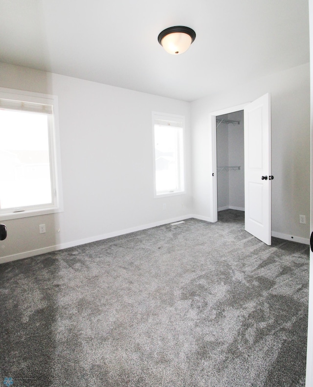 unfurnished bedroom with dark carpet