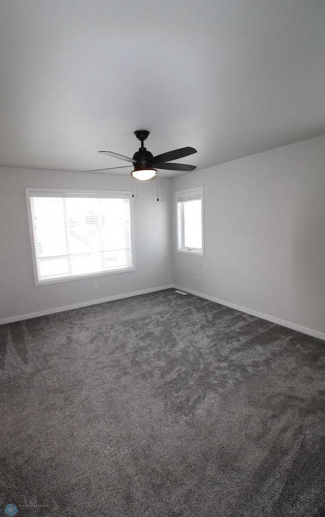 carpeted spare room featuring ceiling fan