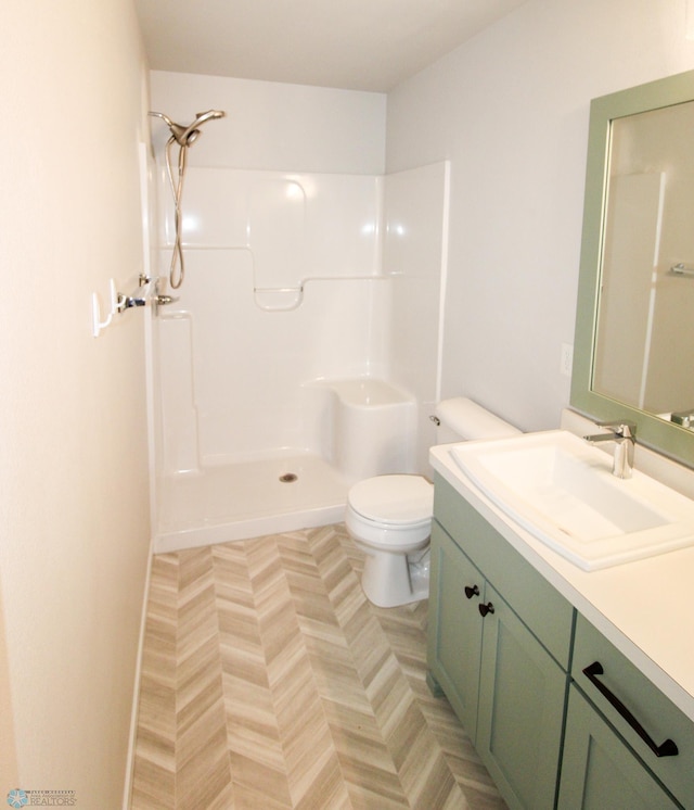 bathroom featuring vanity, toilet, and a shower