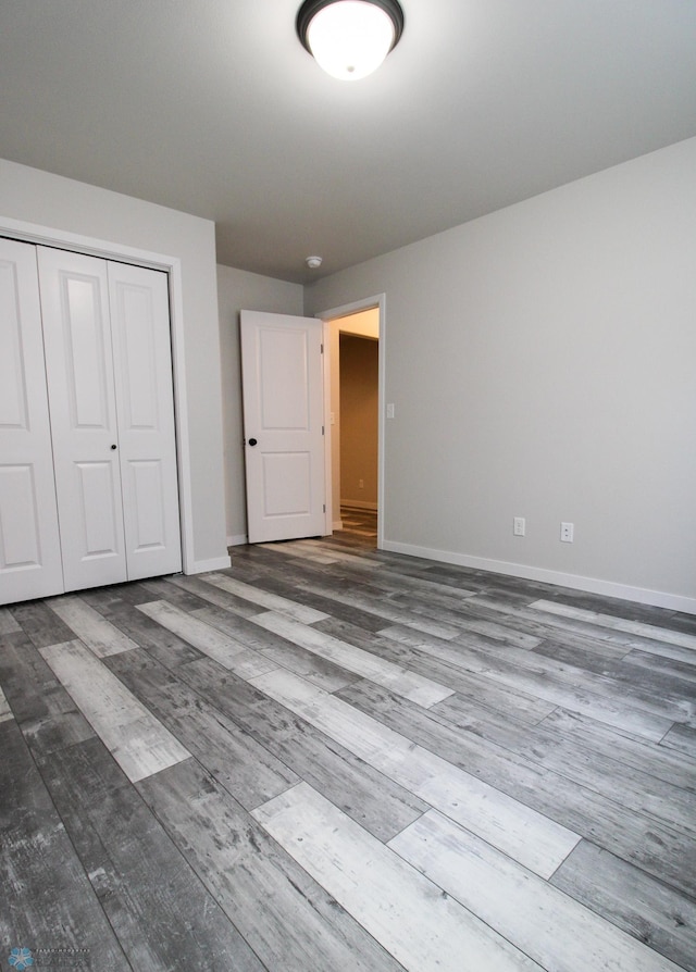 unfurnished bedroom featuring wood-type flooring and a closet