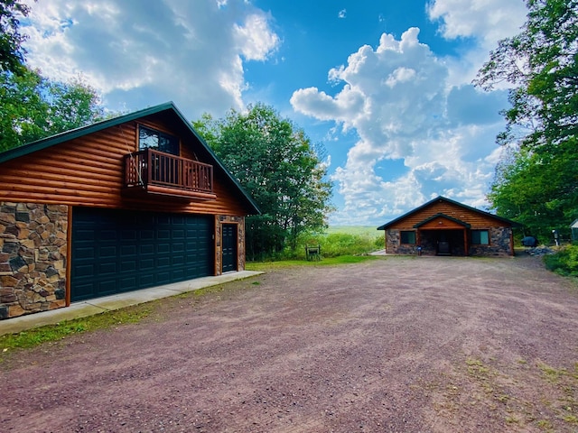 view of side of property featuring a garage and a balcony