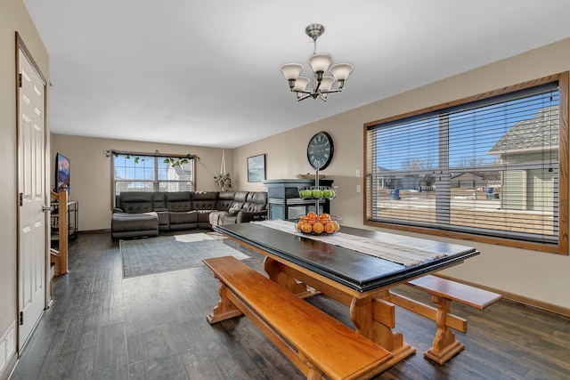 dining room featuring a chandelier, dark wood finished floors, and baseboards