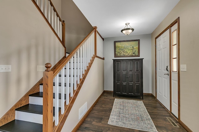 foyer with baseboards, stairs, visible vents, and wood finished floors