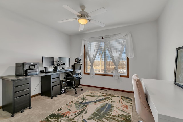 office area featuring baseboards, a ceiling fan, and light colored carpet