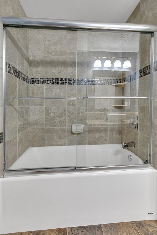 bathroom with combined bath / shower with glass door