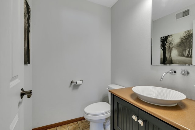 half bathroom featuring visible vents, toilet, vanity, tile patterned flooring, and baseboards