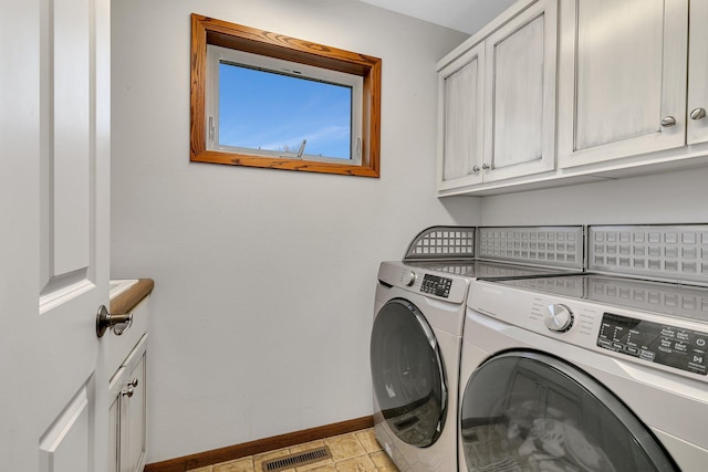 laundry room with visible vents, washer and clothes dryer, cabinet space, and baseboards