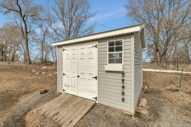 view of shed featuring fence