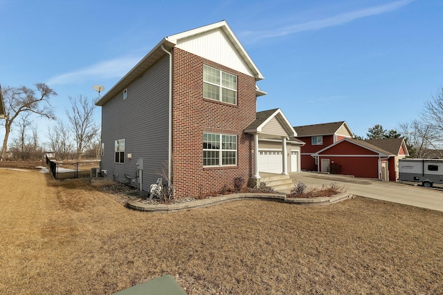 traditional-style home featuring a garage, brick siding, concrete driveway, central AC, and a front yard