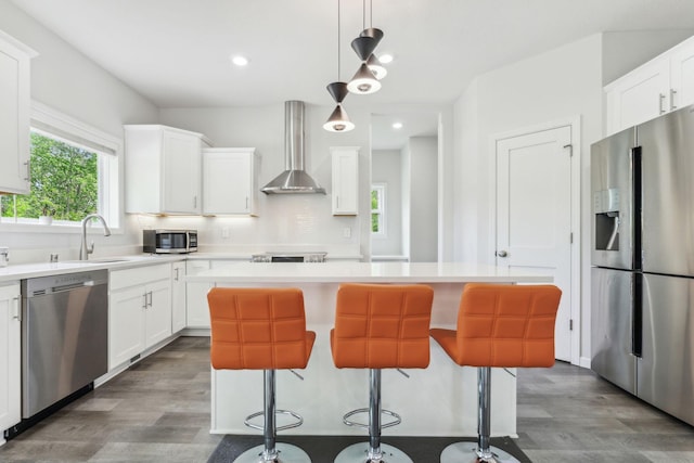 18338 Dove Ct, Eden Prairie, MN 55347 - kitchen with appliances with stainless steel finishes, wall chimney range hood, a kitchen island, and white cabinets