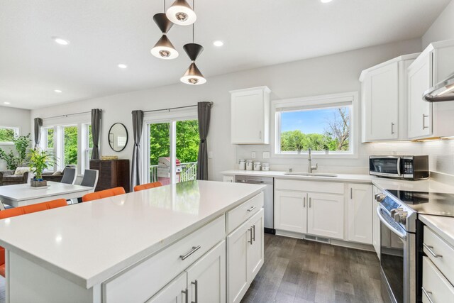 18338 Dove Ct, Eden Prairie, MN 55347 - kitchen with appliances with stainless steel finishes, a center island, hanging light fixtures, and white cabinets