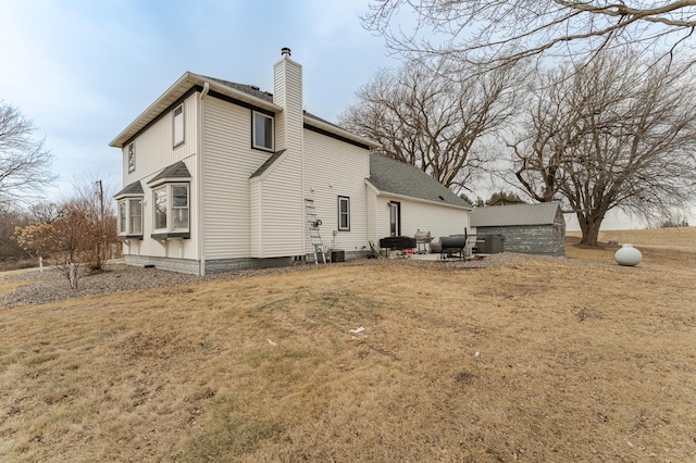 view of home's exterior with a storage unit and a lawn