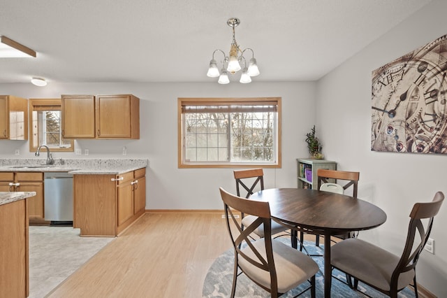 dining area with light hardwood / wood-style flooring, sink, plenty of natural light, and a chandelier