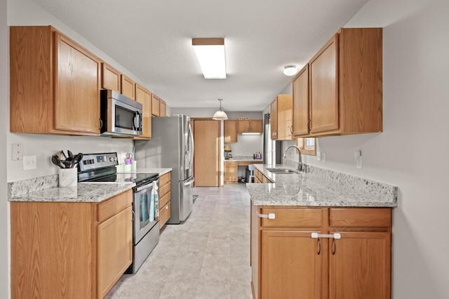 kitchen featuring appliances with stainless steel finishes, light stone countertops, sink, and a textured ceiling