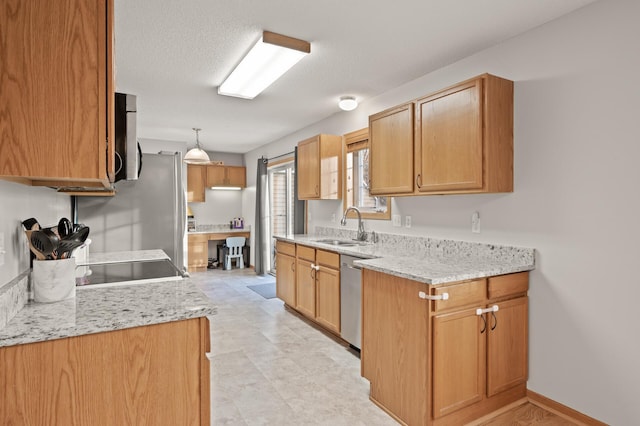 kitchen featuring sink, decorative light fixtures, light stone countertops, and appliances with stainless steel finishes