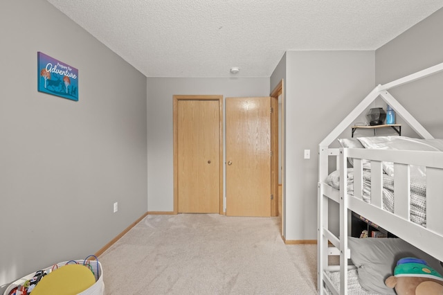 carpeted bedroom featuring a textured ceiling and a closet