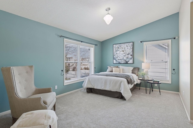 carpeted bedroom with vaulted ceiling and a textured ceiling