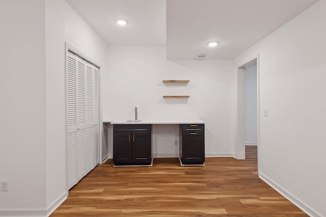 bar with sink and light wood-type flooring