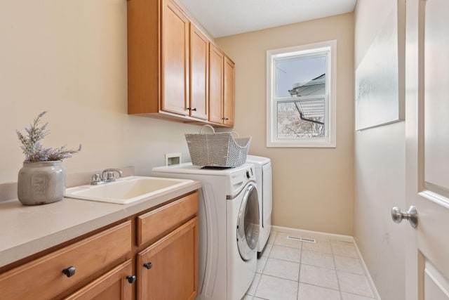 laundry area with washer and dryer, sink, cabinets, and light tile patterned flooring