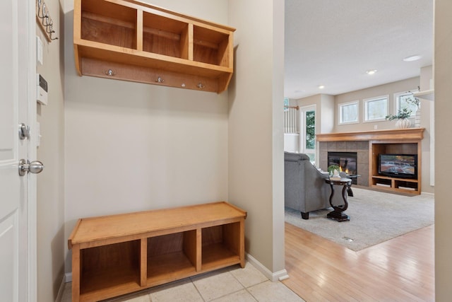 mudroom featuring a fireplace and light hardwood / wood-style flooring