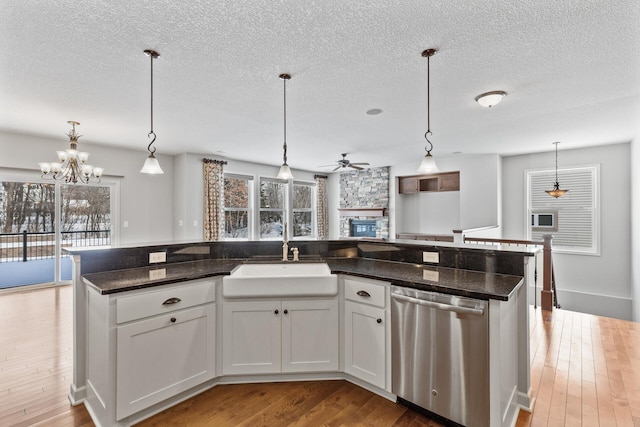 kitchen with white cabinetry, stainless steel dishwasher, and pendant lighting