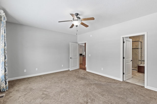 unfurnished bedroom with ensuite bathroom, light colored carpet, ceiling fan, and a textured ceiling