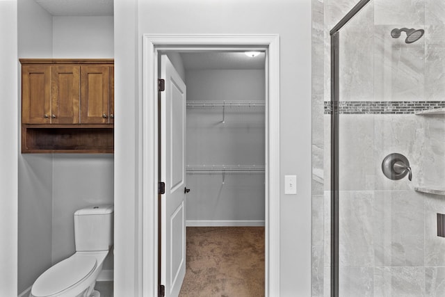 bathroom featuring toilet and a shower with door