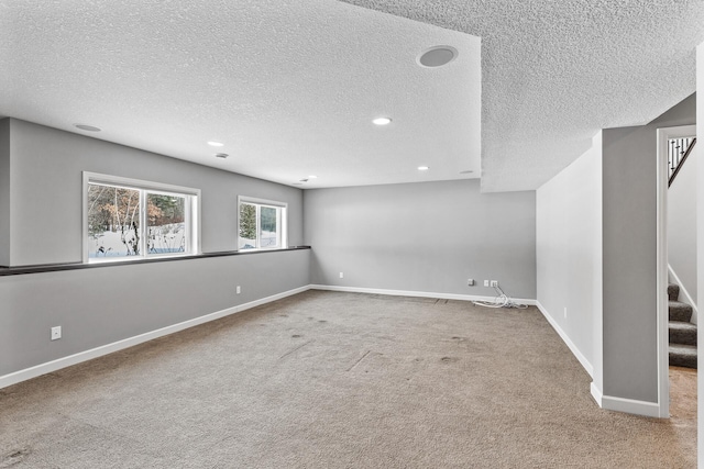 empty room with a textured ceiling and carpet flooring