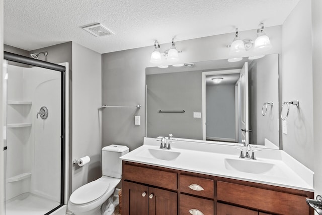 bathroom with vanity, a textured ceiling, a shower with door, and toilet