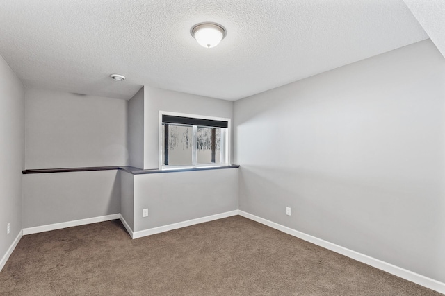 spare room featuring carpet floors and a textured ceiling