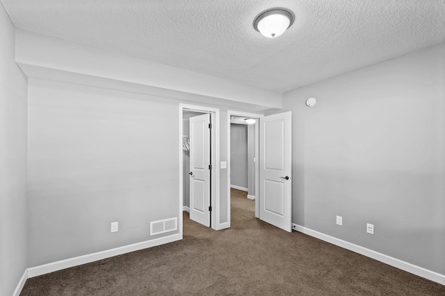 carpeted spare room with a textured ceiling