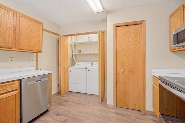 kitchen featuring independent washer and dryer, stainless steel appliances, light hardwood / wood-style floors, and a textured ceiling