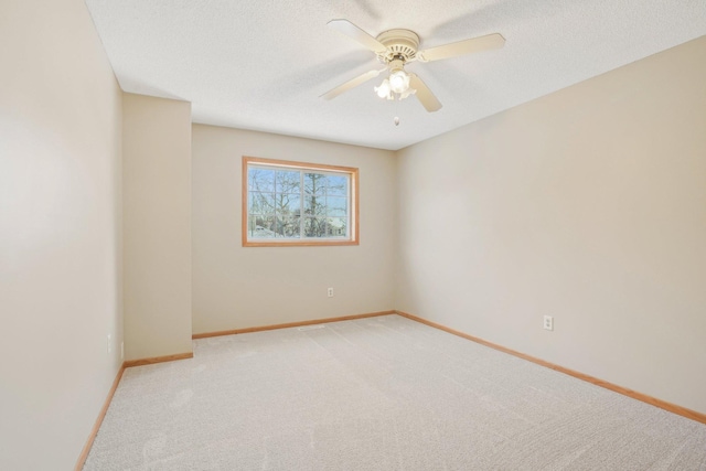 carpeted empty room featuring ceiling fan and a textured ceiling